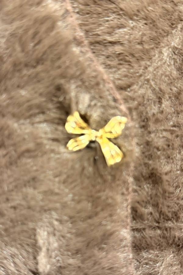 mysig kofta med guldiga rosettknappar