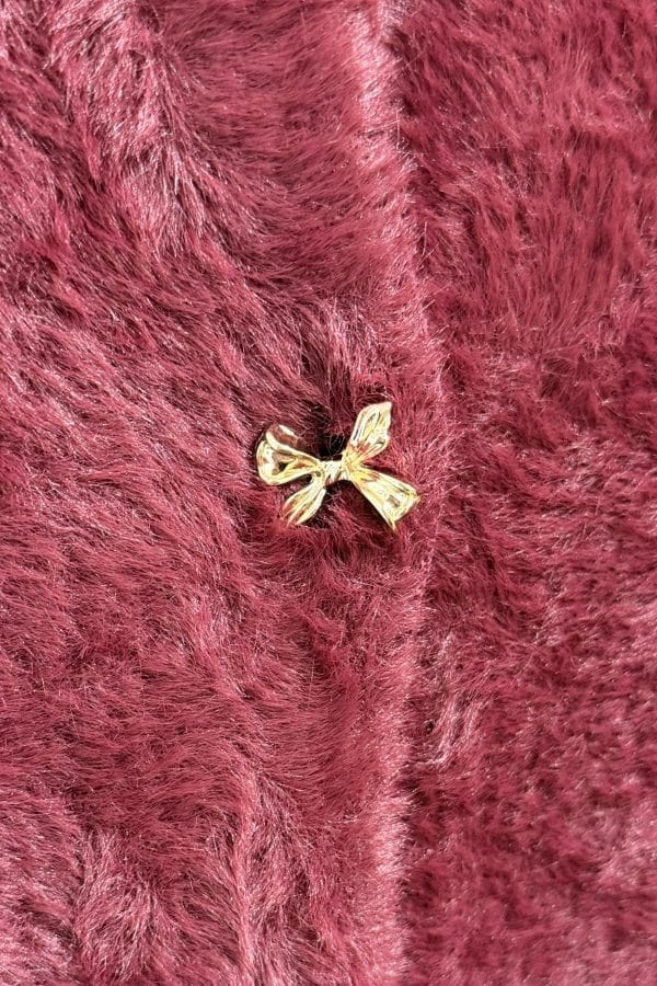 mysig kofta med guldiga rosettknappar