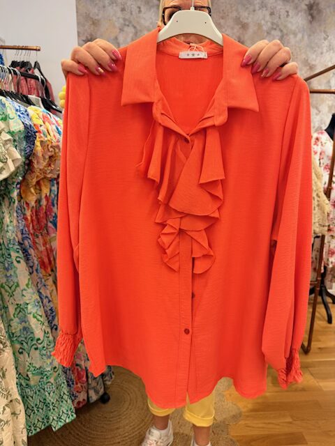 Orange blus med volang framtill