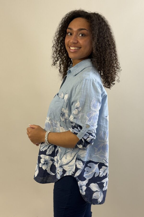 Ljusblå genomknäppt blus med blombård nertill