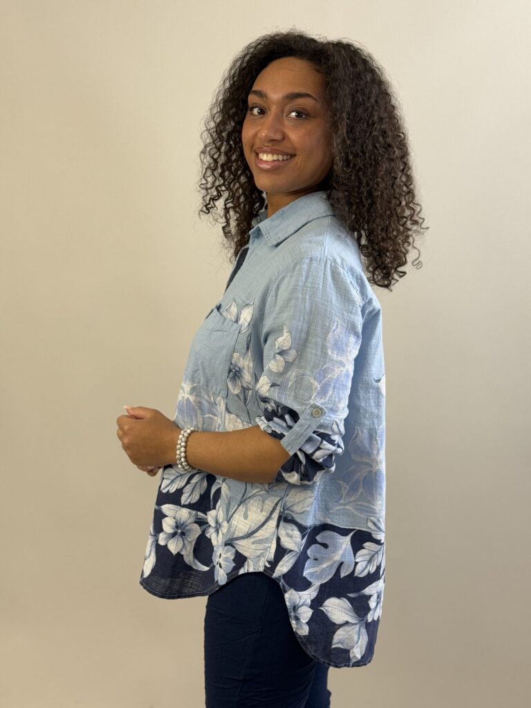 Ljusblå genomknäppt blus med blombård nertill