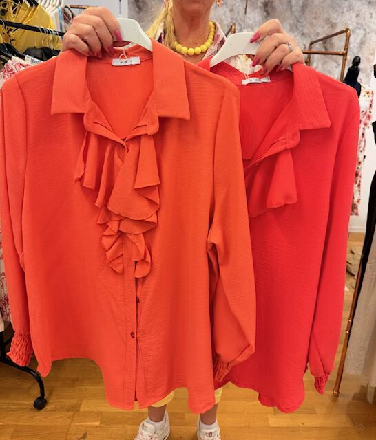 Orange blus med volang framtill