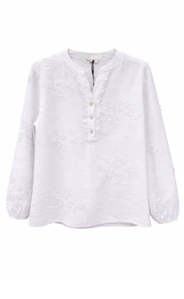 Vit blus med blomapplikationer