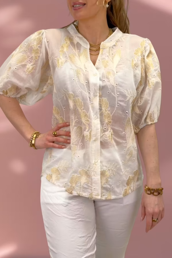 Vit blus med blommor i guld