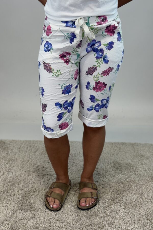 Stretchiga caprishorts i blommönster på vit botten