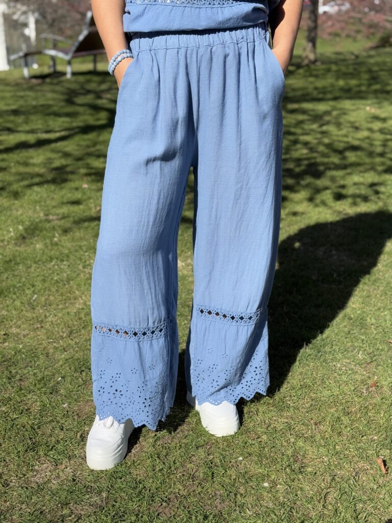 Jeansblå byxa med brodyr nertill och fickor i sidan
