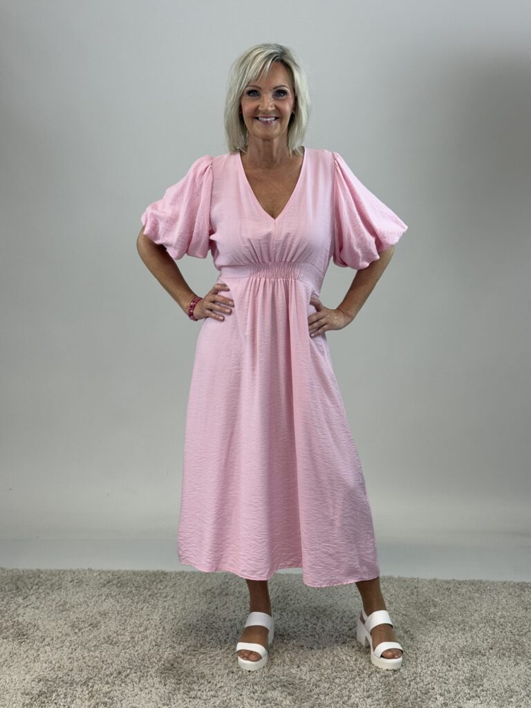 Rosa klänning med resår framtill och en puffärm