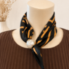 Elegant satinscarfs med magnetpärla i grafiskt mönster svart/konjak
