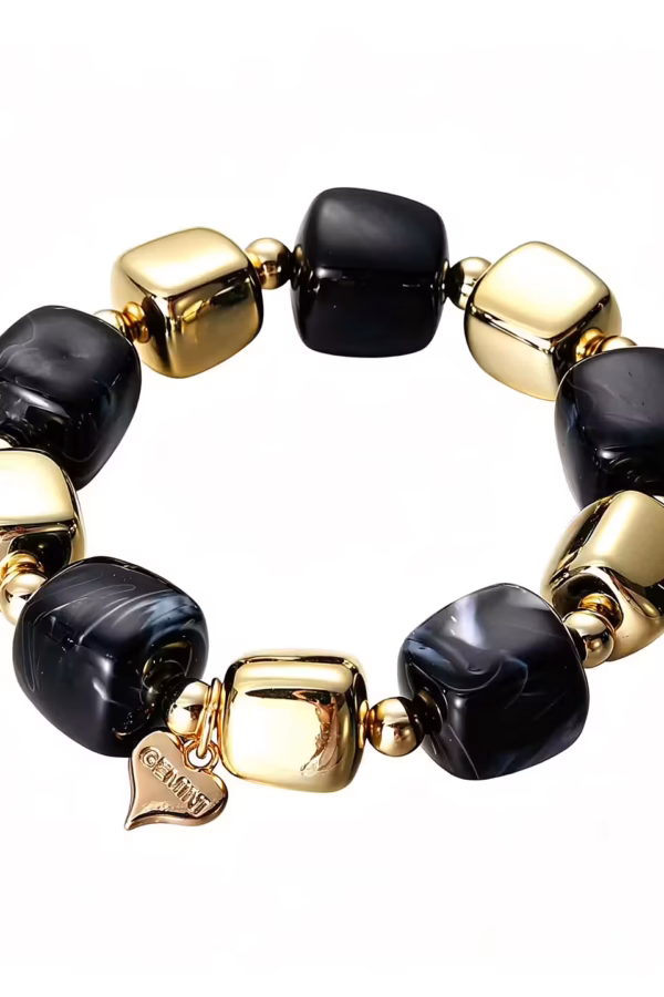 Coolt armband i fräck design med svarta och guldiga stenar